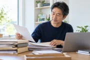 記事や資料の保管内容を整理しながらホームページのリニューアルを考える架空の日本人男性の生成イメージ